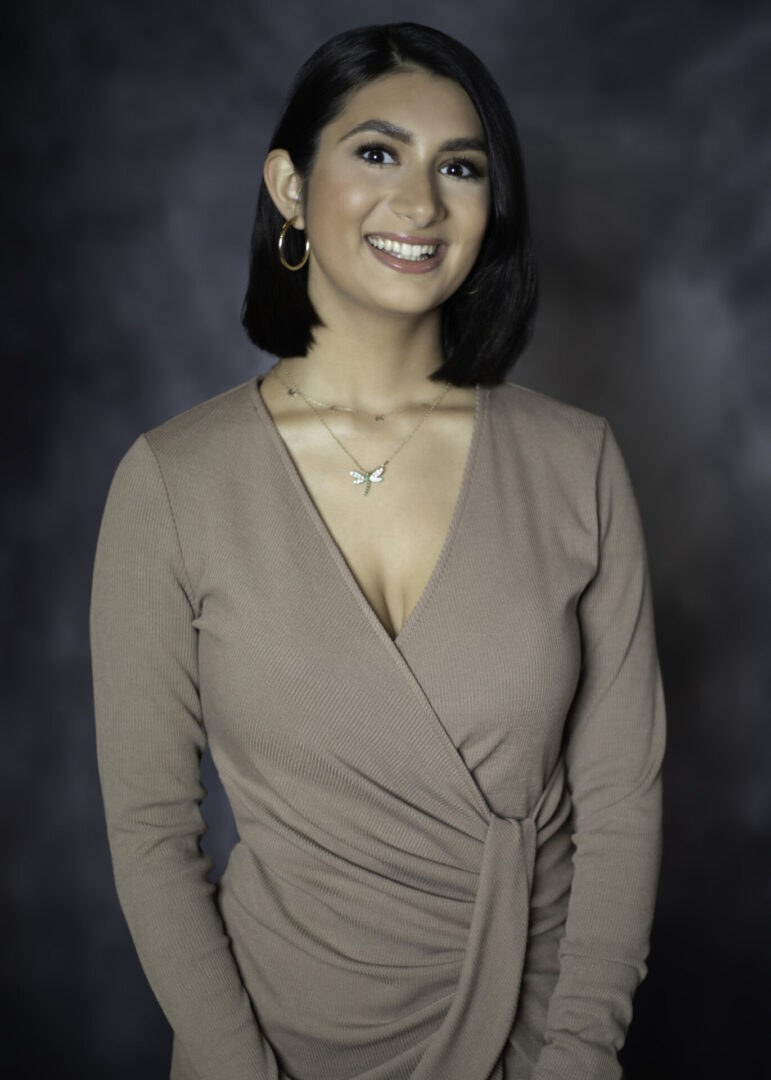 Smiling headshot of a woman in beige outfit